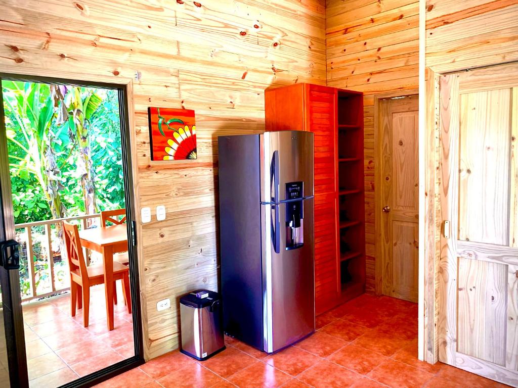 Cocina de Ocean Melody 3 con refrigeradora, armario rojo y puertas de madera
