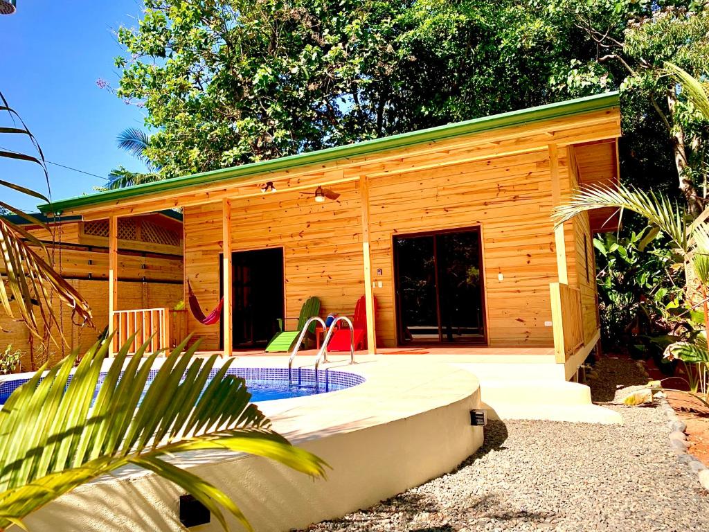 Fachada de madera de Ocean Melody 4 con hamaca, sillones de colores y piscina