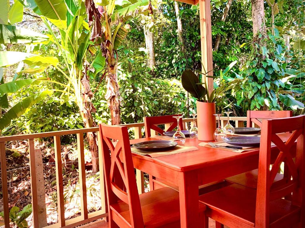 Comedor de madera de Ocean Melody 3 en la terraza, con la mesa puesta entre la vegetación tropical