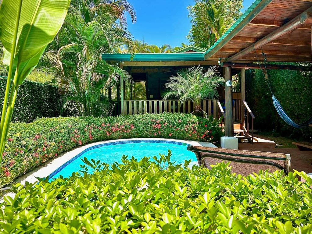 Piscina privada y terraza de madera de Ocean Melody 1 entre jardines tropicales