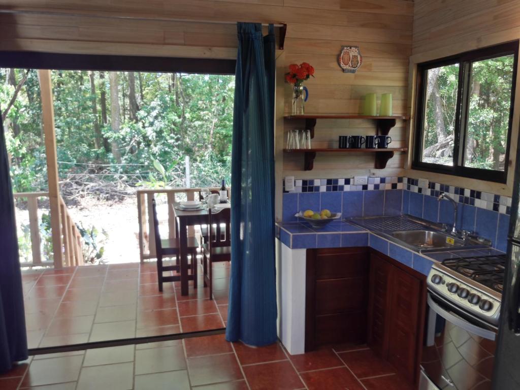 Cocina de Ocean Melody 2 con azulejos azules y comedor junto a la terraza