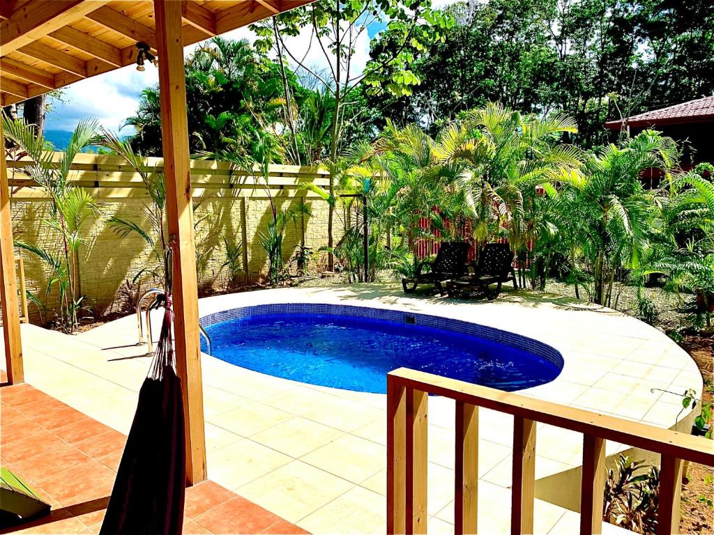 Piscina privada de Ocean Melody 4 con sombrilla, tumbonas y hamaca en la terraza techada